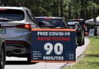 People in cars wait at a Covid testing and vaccination site at Barnett Park in Orlando, Florida