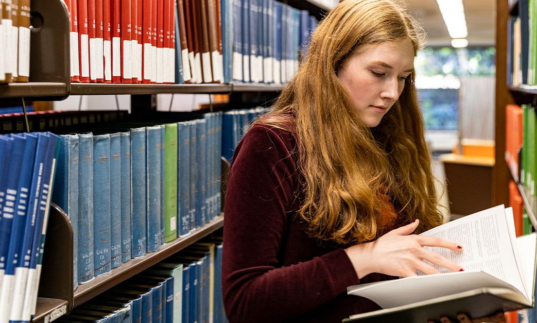student in a library reading